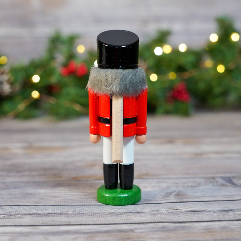 Full View of Mini Red Hussar Nutcracker Standing on Wooden Table