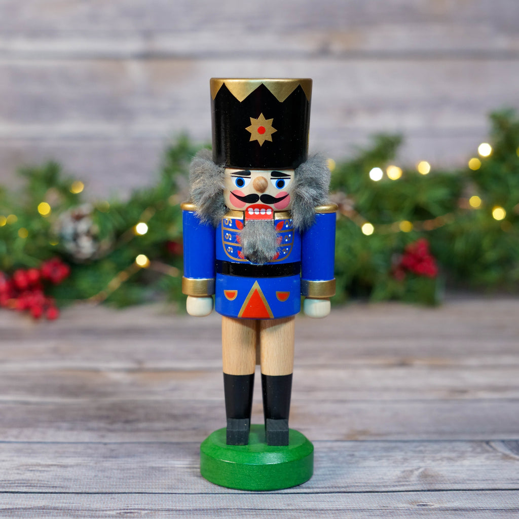 Dark blue soldier nutcracker standing with festive background