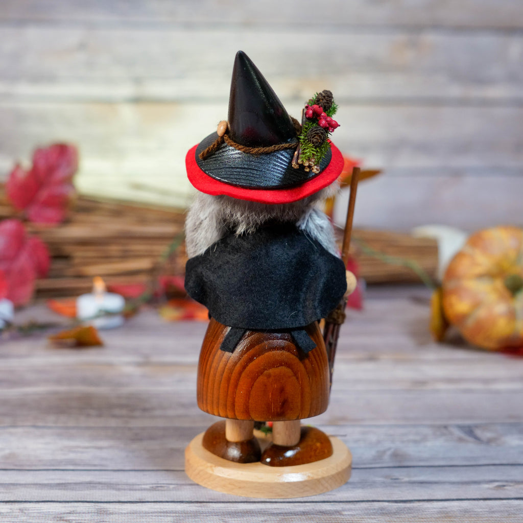 Witch holding a broomstick with wooden details
