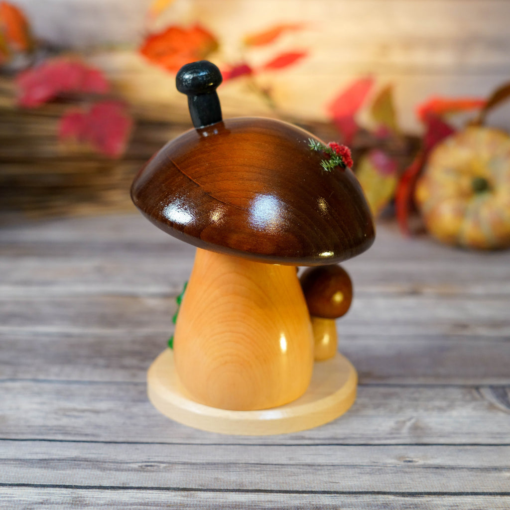Rustic wooden base of Mushroom House Smoker with miniature holiday accents