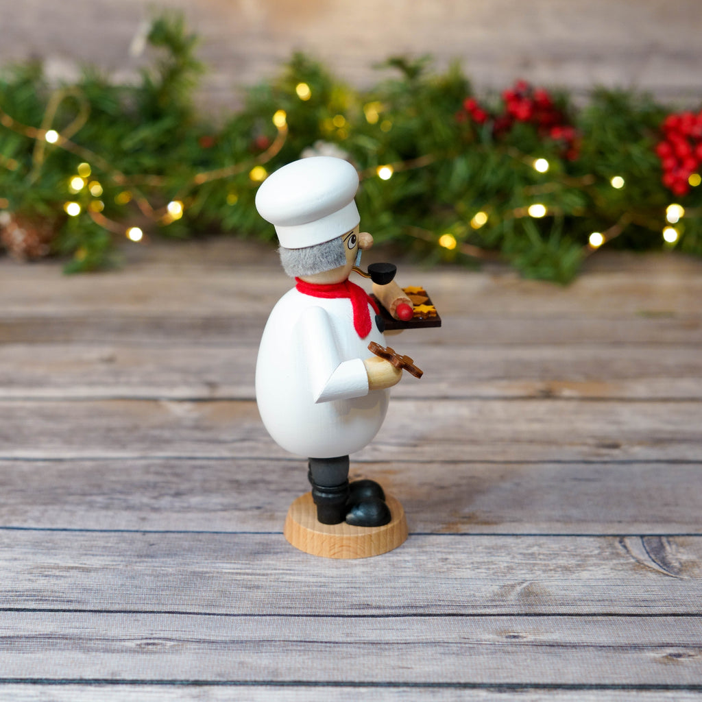Detailed view of gingerbread man cookie held by baker smoker
