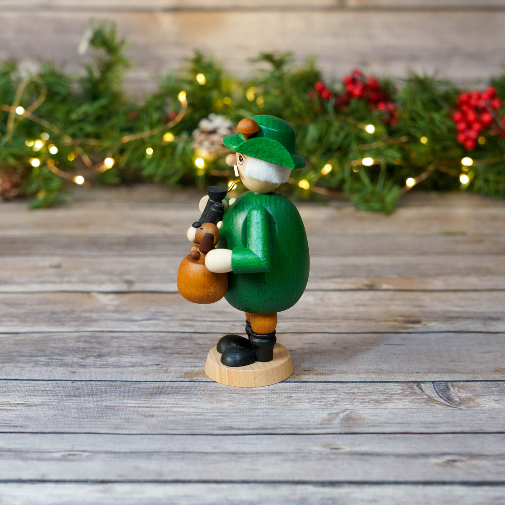 German smoker with traditional outfit standing beside festive background