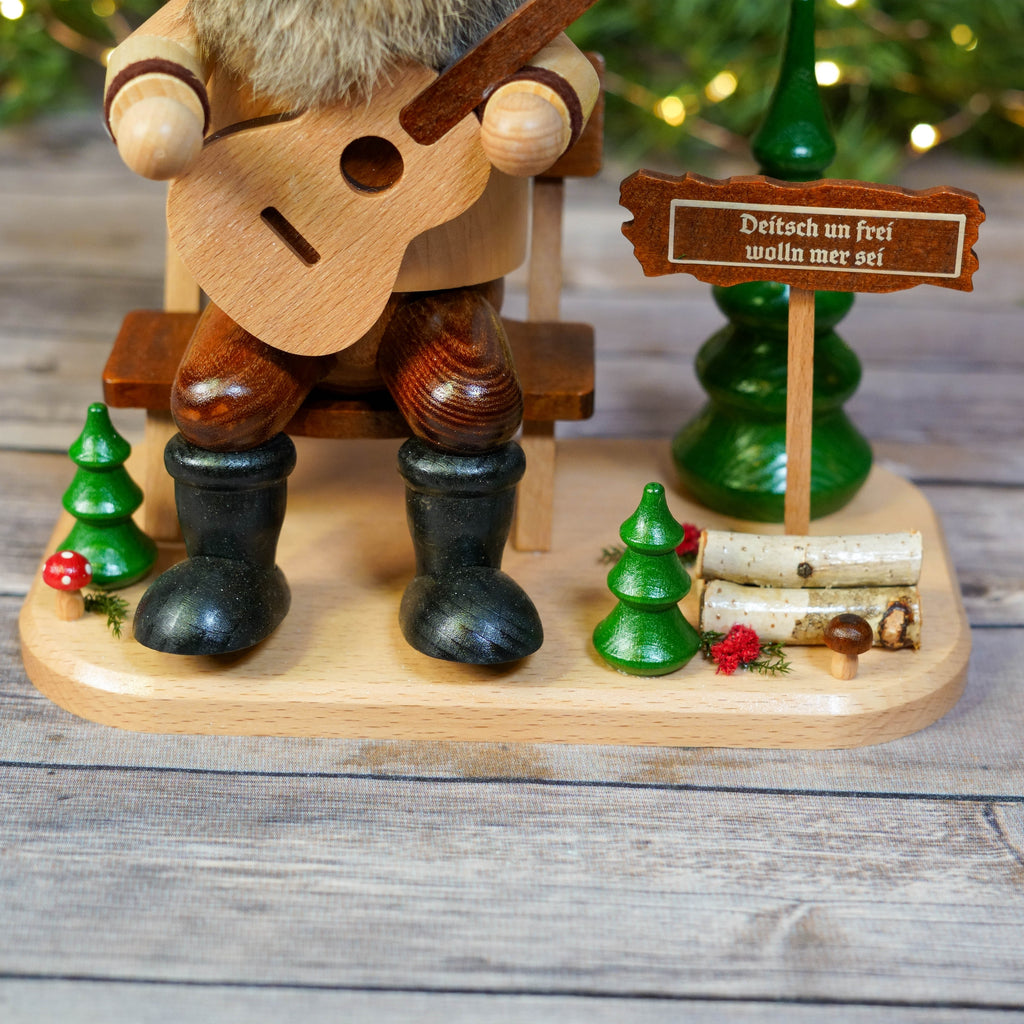 Full view of German guitar player smoker with holiday backdrop