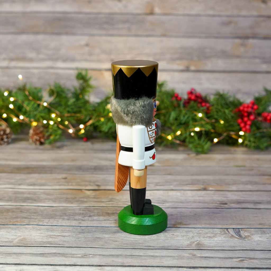 Full view of White King Nutcracker with festive greenery in background
