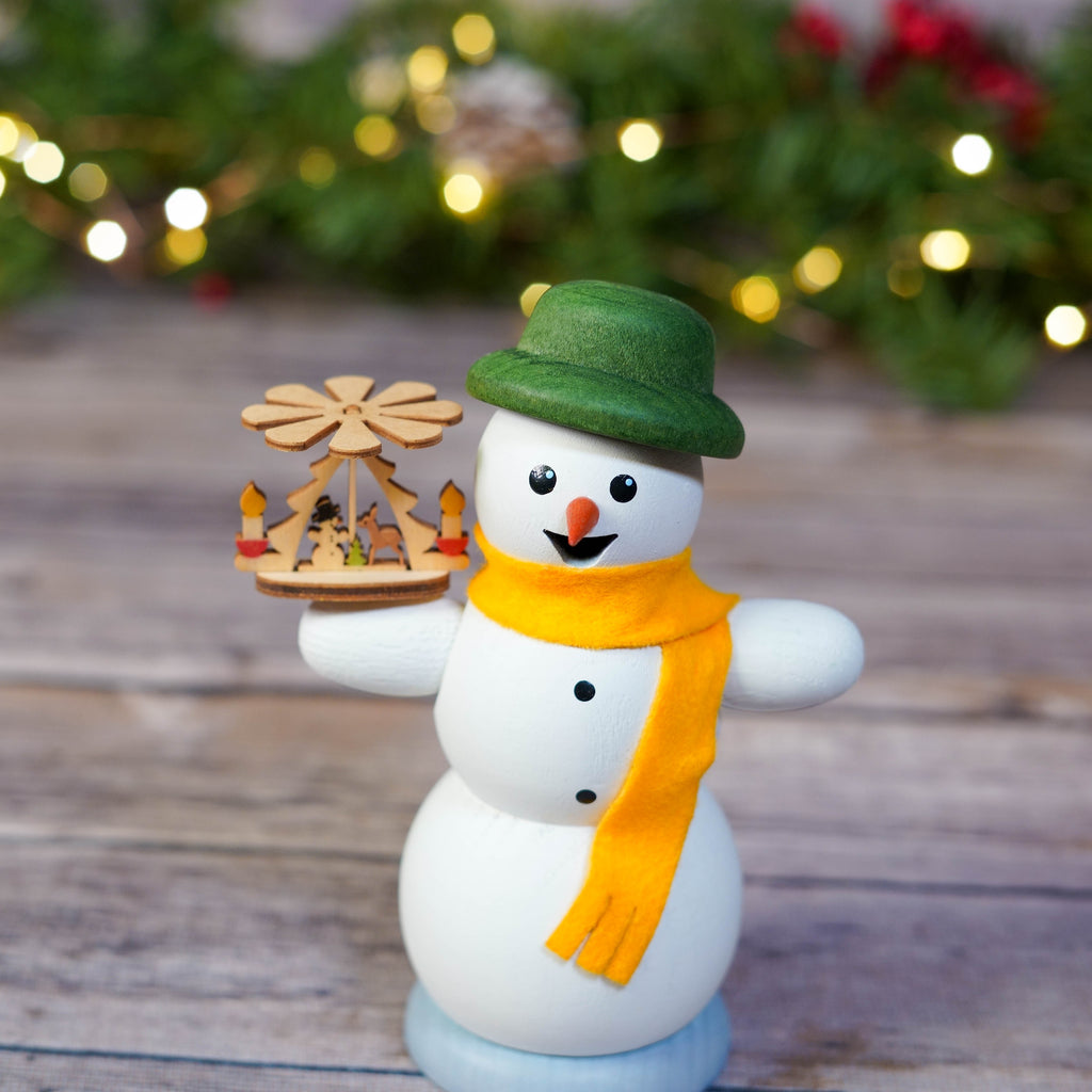 Side view of snowman smoker with German pyramid against holiday backdrop