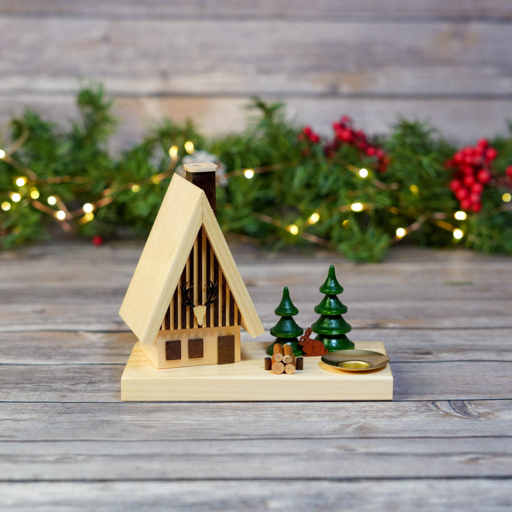 German incense smoker house with candle on festive backdrop