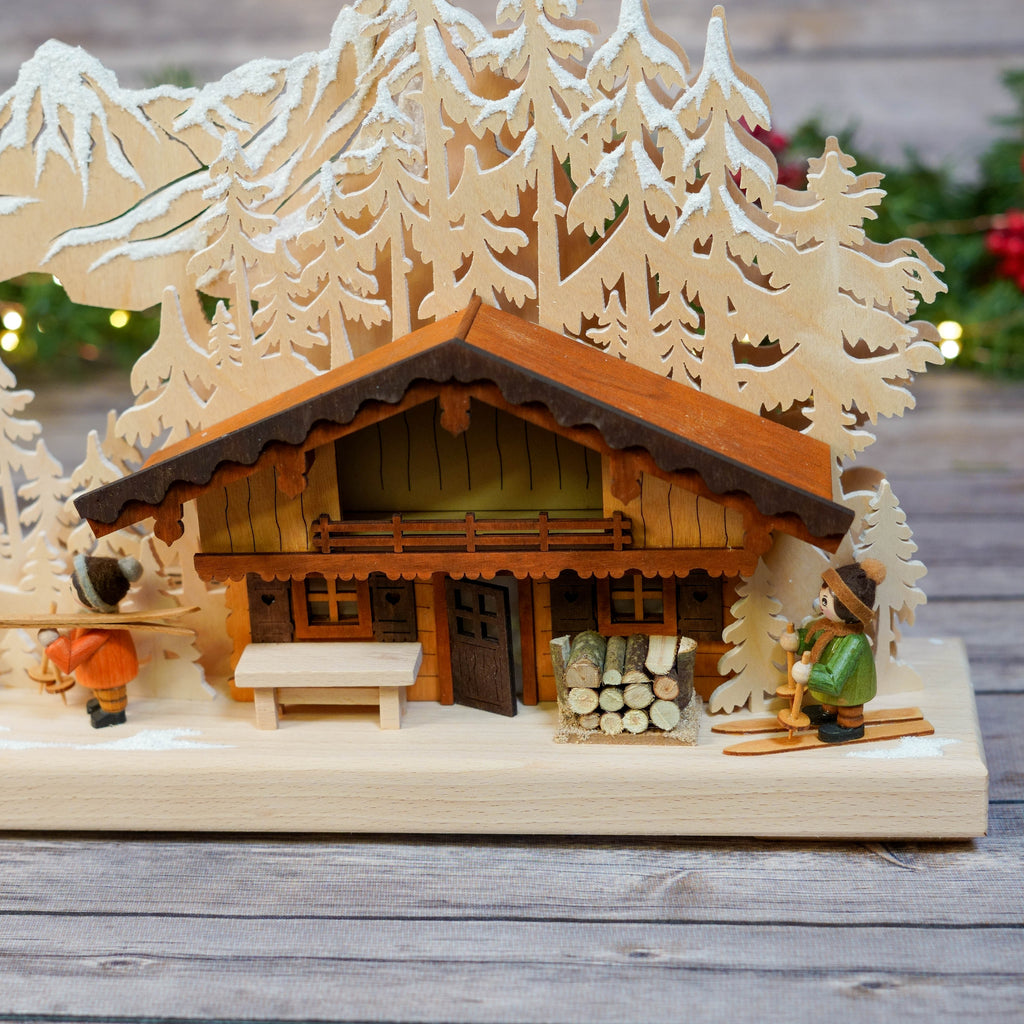 Close-up of hand-painted figurines by wooden ski lodge