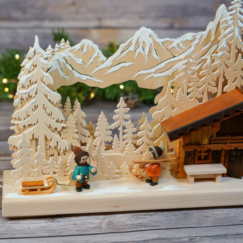 Side view of wooden Schwibbogen ski lodge with snowy mountains