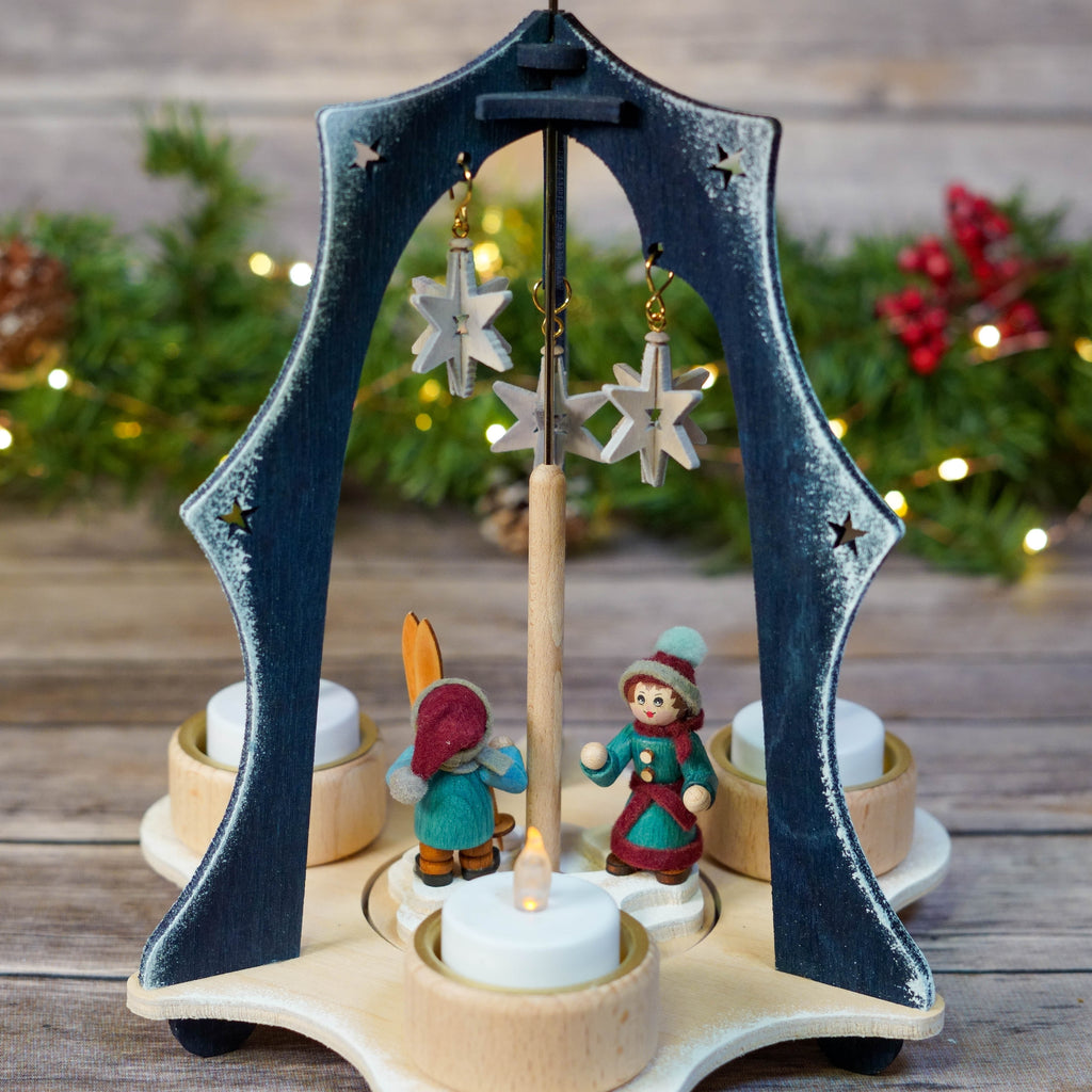 Detailed view of wooden skiers on blue triangular Christmas pyramid