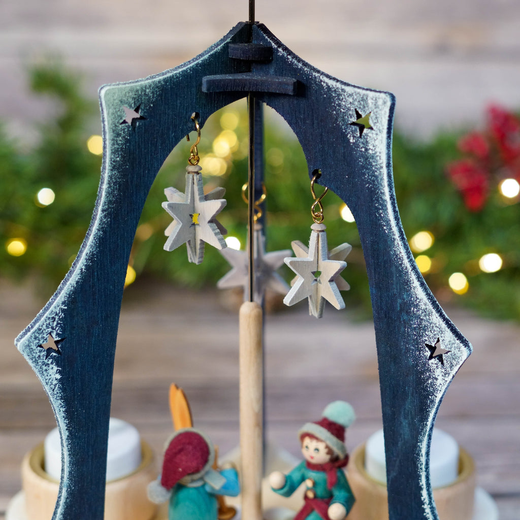 Christmas pyramid against festive backdrop with lights and greenery