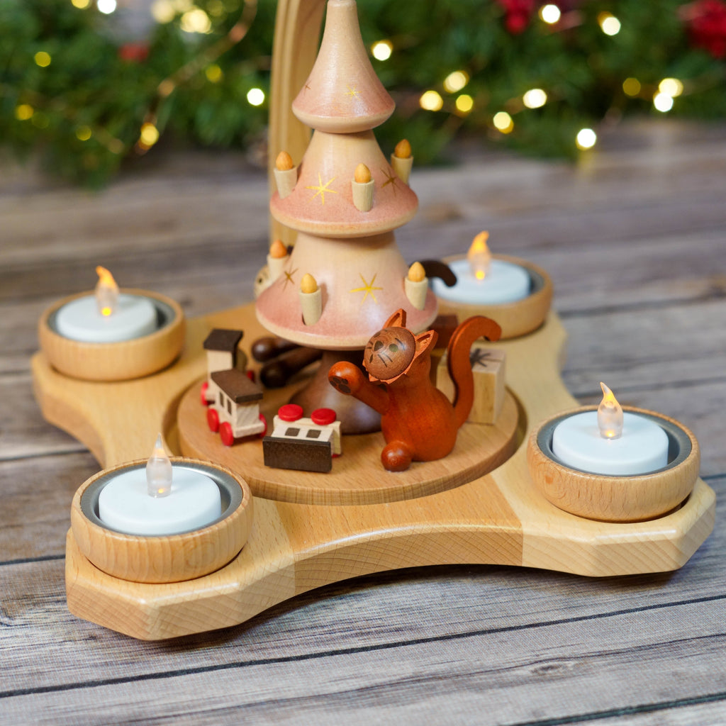 Close-up of cats playing around a Christmas Pyramid